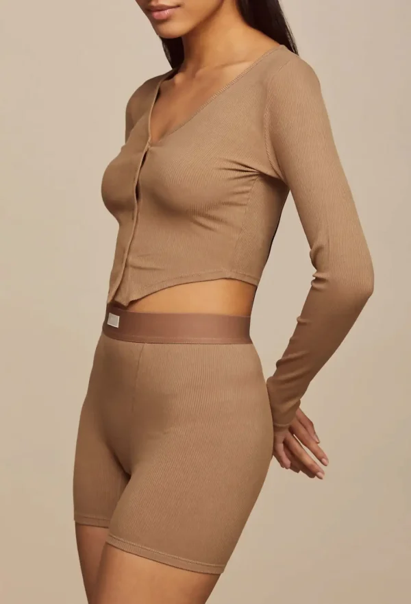 Side view of woman wearing Shiitake Flaxseed-Freedom Flow ribbed cardigan and bike shorts showing fitted silhouette and texture