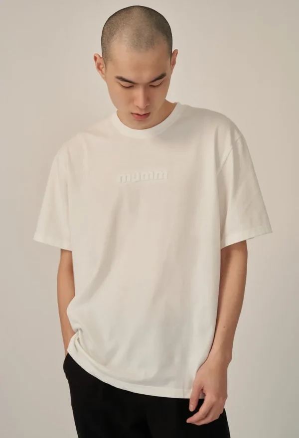 Front view of man wearing white recycled pet t-shirt with embossed logo in studio setting