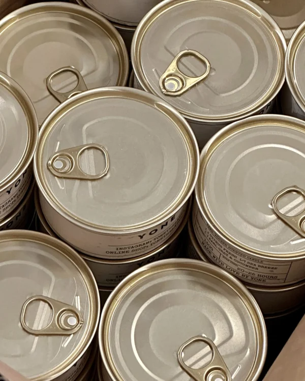 Collection of unopened Daily Reminder Candle tins with pull-tab lids arranged in overhead flat lay