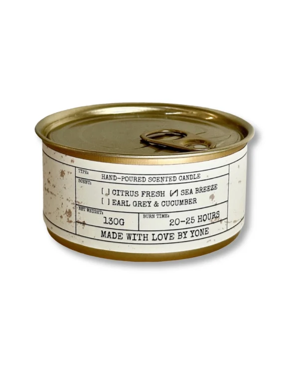 Daily Reminder Candle in gold tin featuring earl grey & cucumber, citrus fresh and sea breeze scents on white background